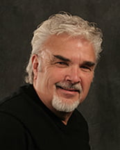 a man with a white beard and a black shirt.