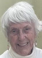 an older woman with white hair smiling at the camera.