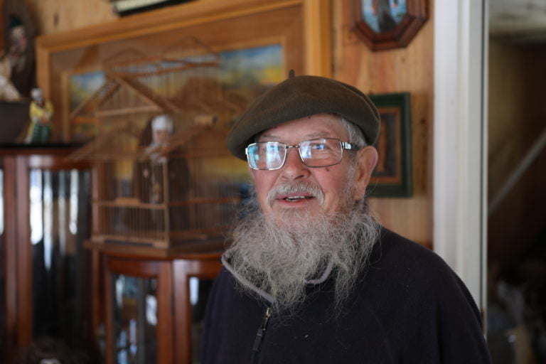 a man with a long beard wearing glasses and a hat.