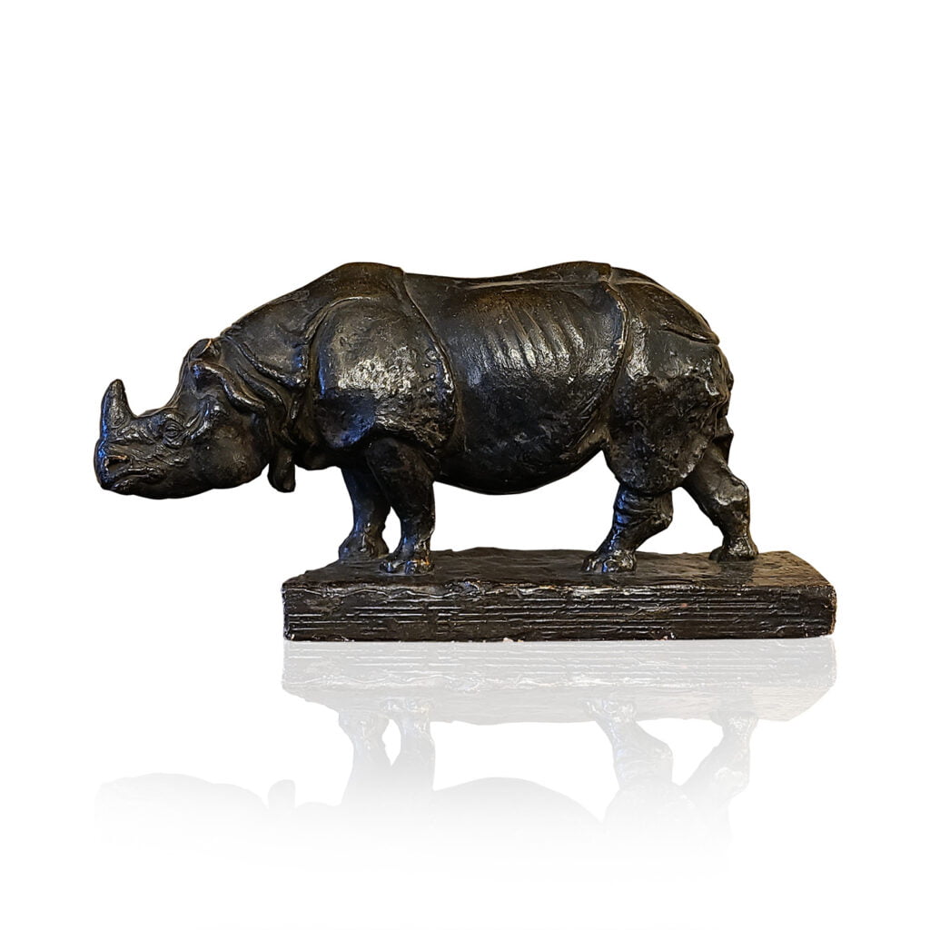 a bronze statue of a rhinoceros on a white background.