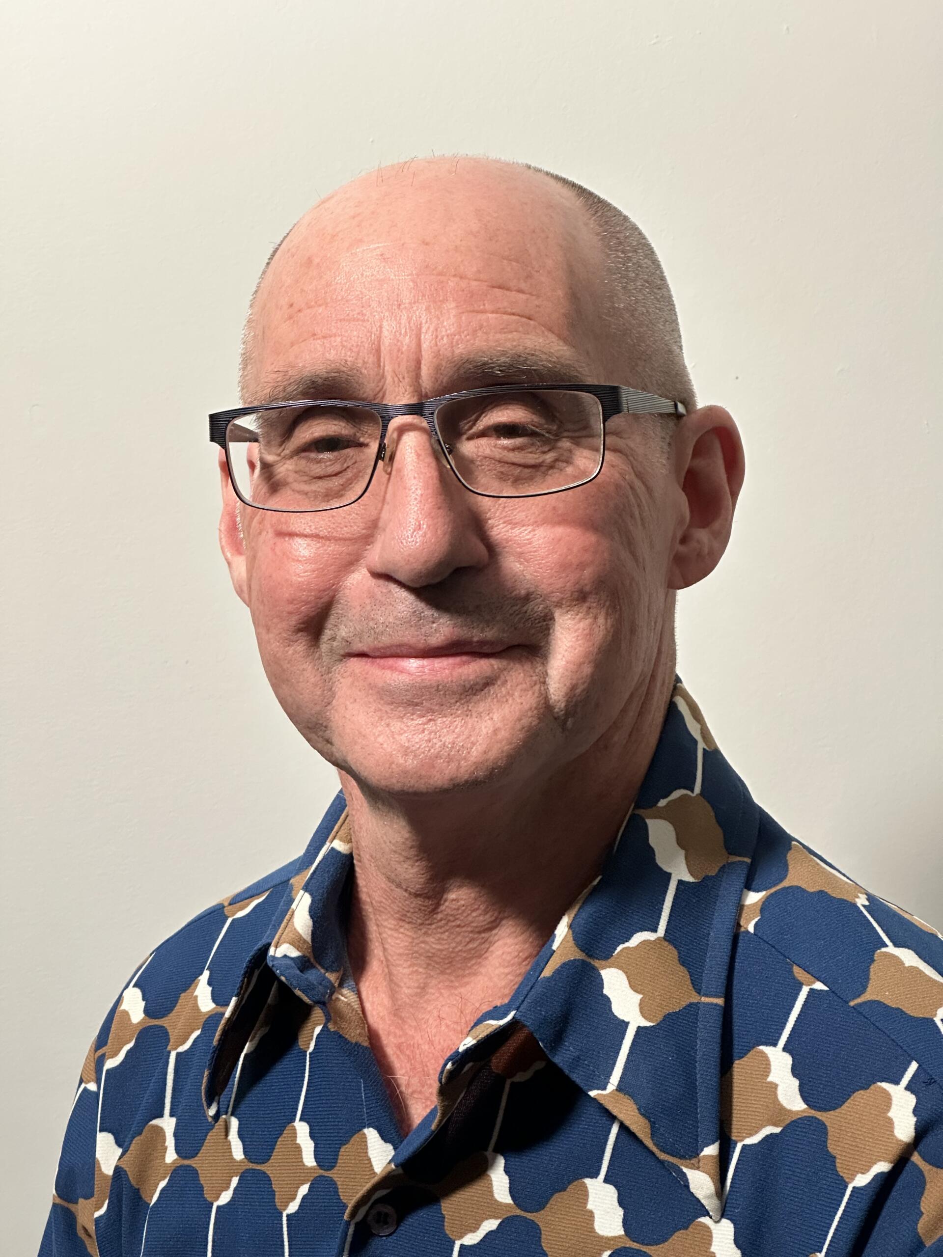 a man wearing glasses and a blue shirt.