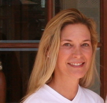 a woman in a white shirt holding a glass of wine.
