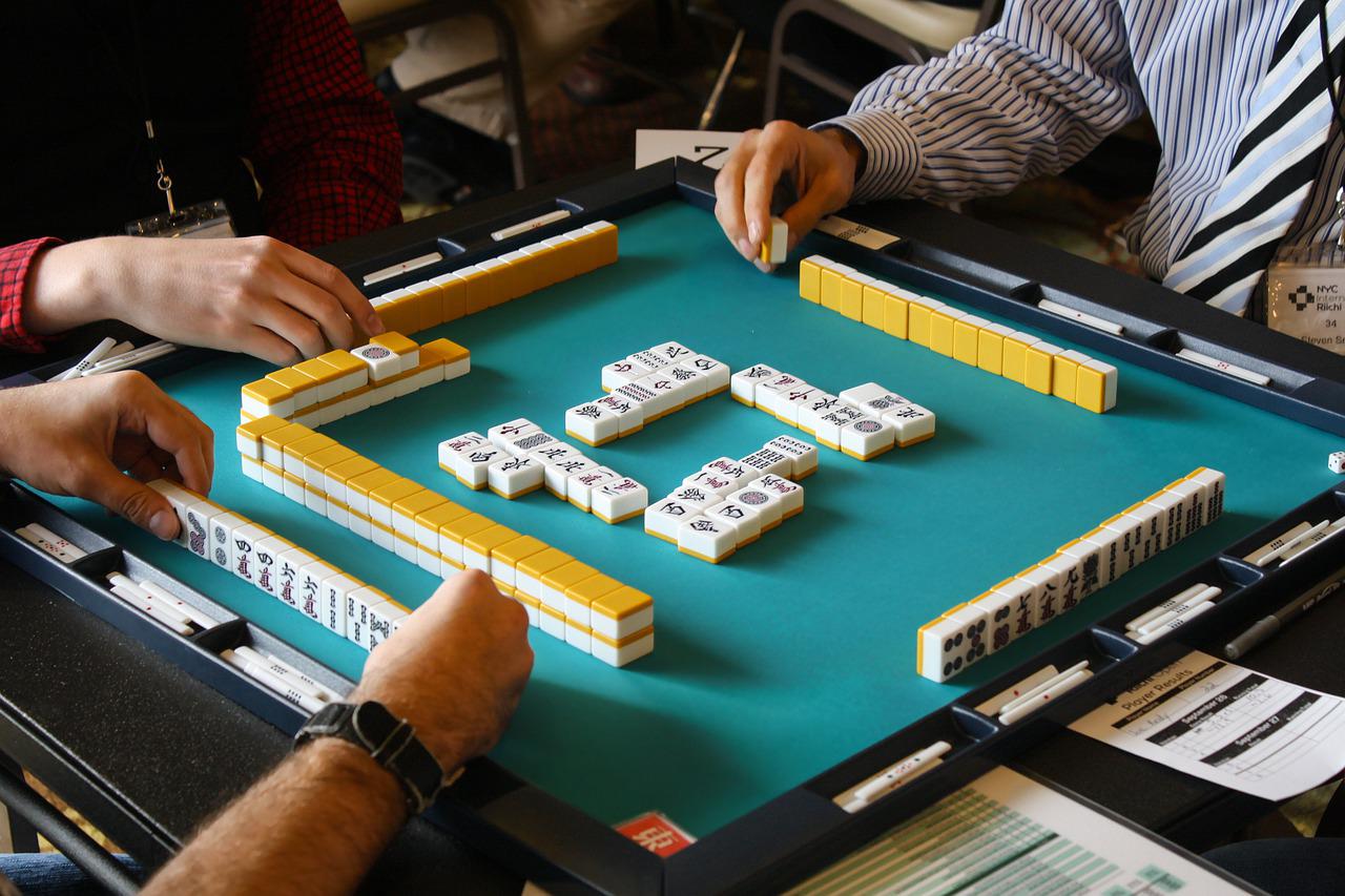 People playing mahjong around table