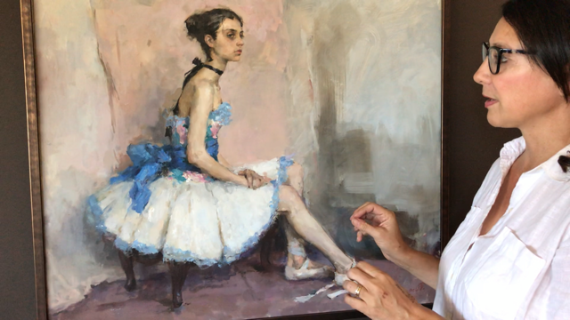 Vanessa Rothe, a woman with dark hair and thick rimmed glasses, gazes at a painting of a ballerina in a floral blue dress.