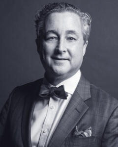 In black and white: Raymond J. Dowd is a friendly-looking middle-aged man wearing a suit and bow tie.