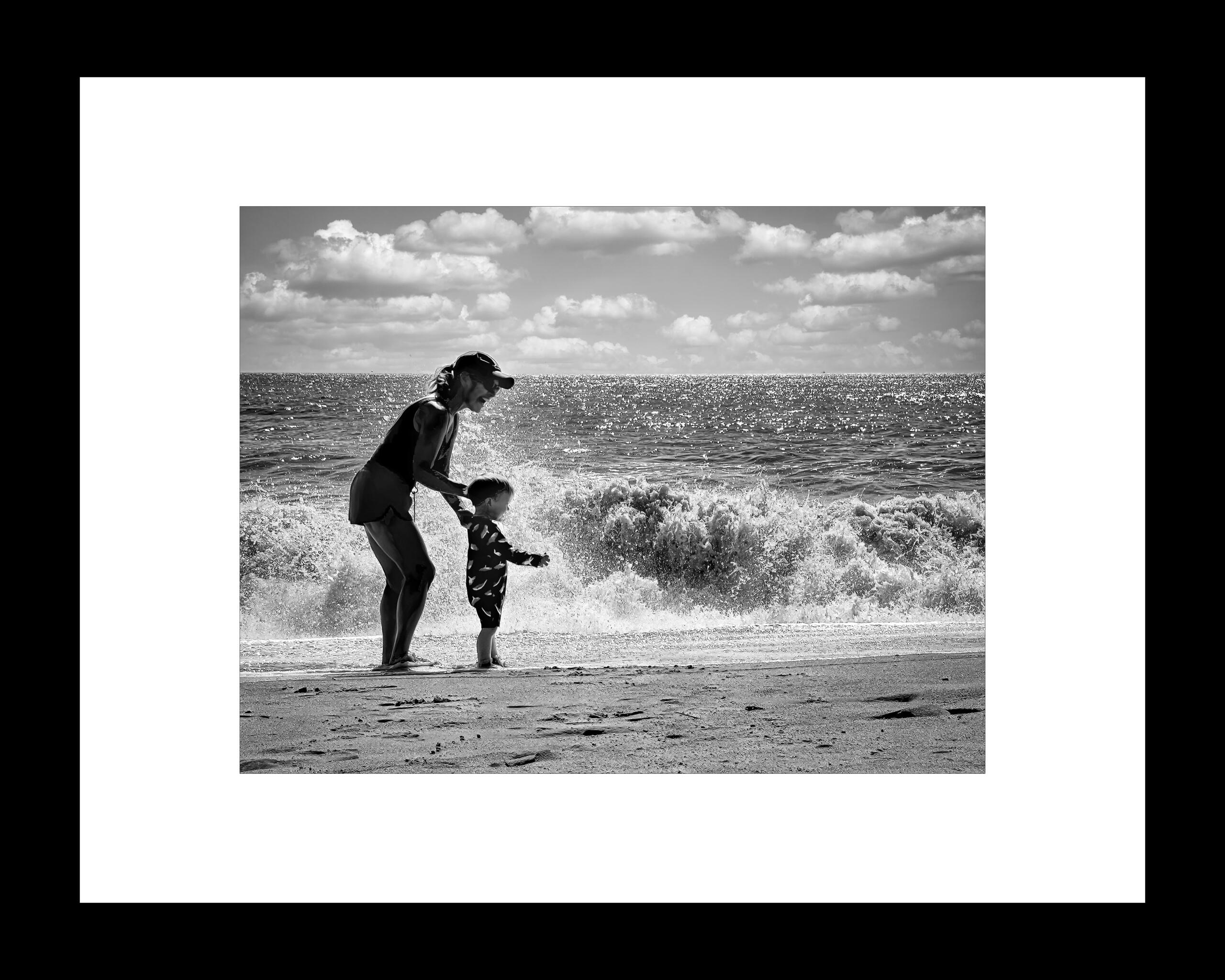 "Watching the waves" in a white matte and black frame.