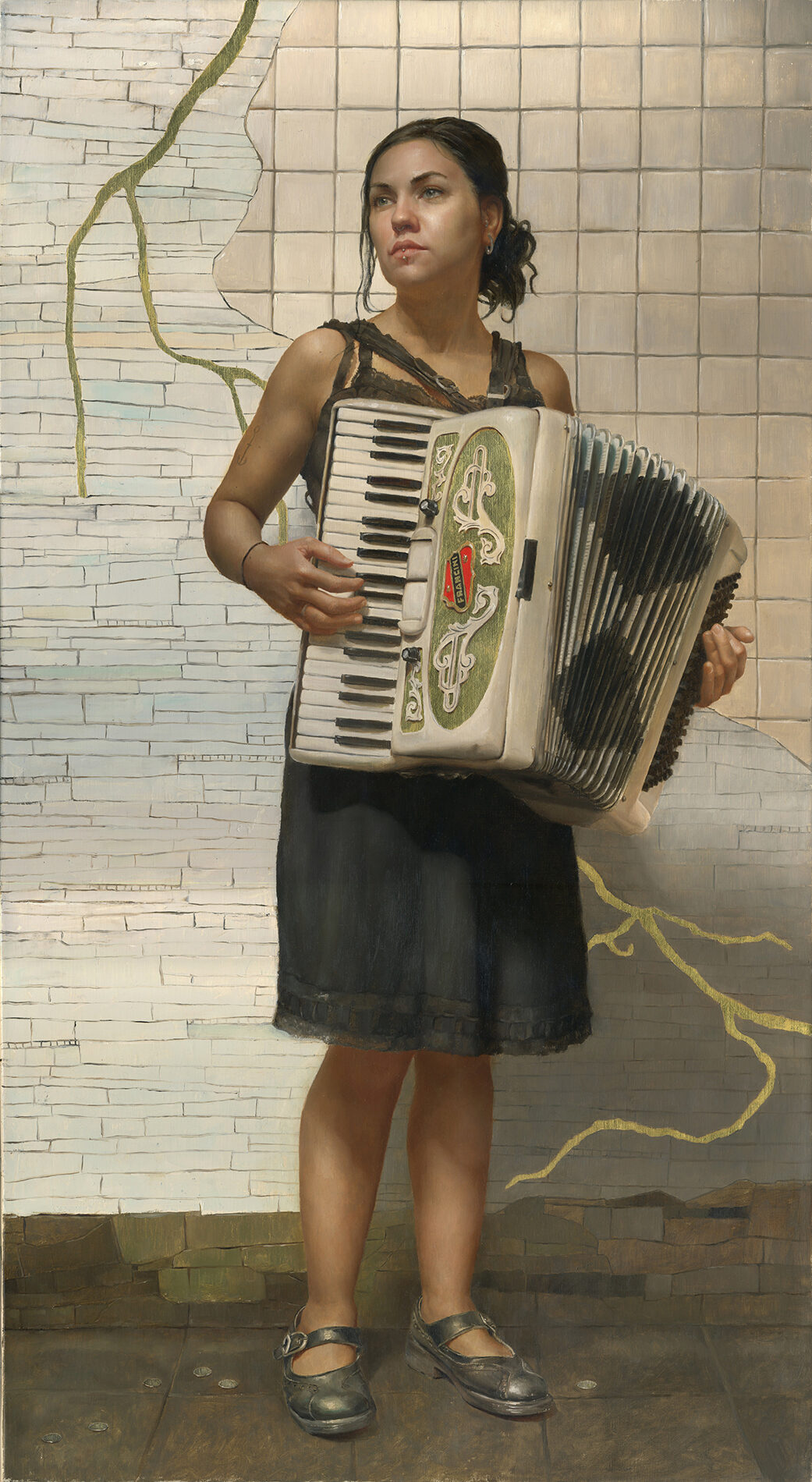 A young woman, standing in a subway platform, playing an accordion.