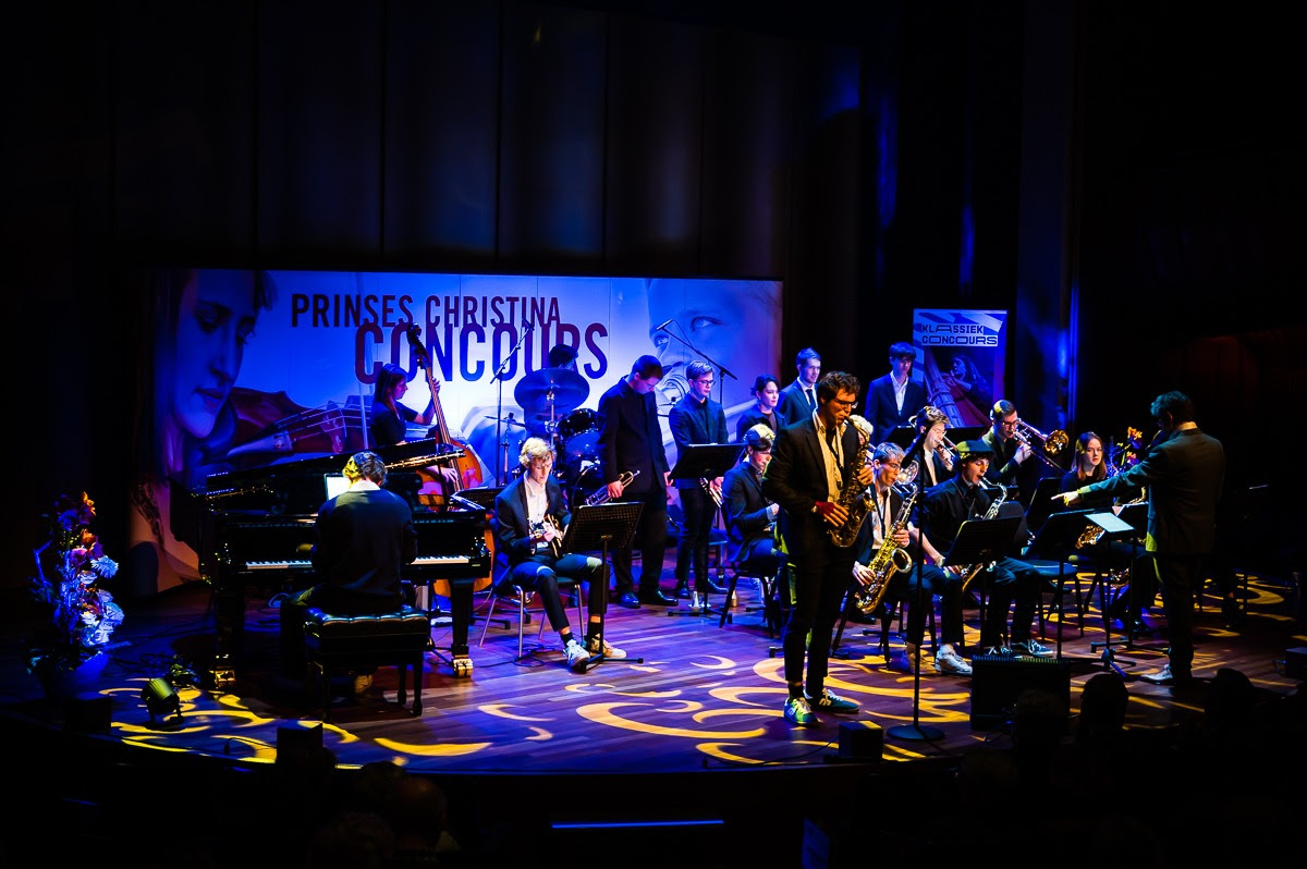 A jazz group plays on stage, under moody blue and yellow lighting.