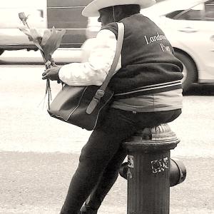 A man sitting on a fire hydrant.
