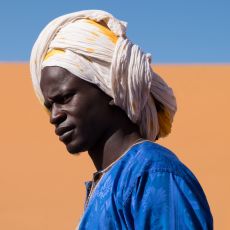 A man wearing a turban in the sahara desert.
