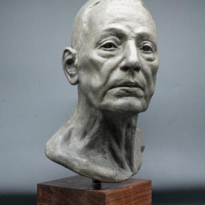 A bust of an old man on a wooden base.