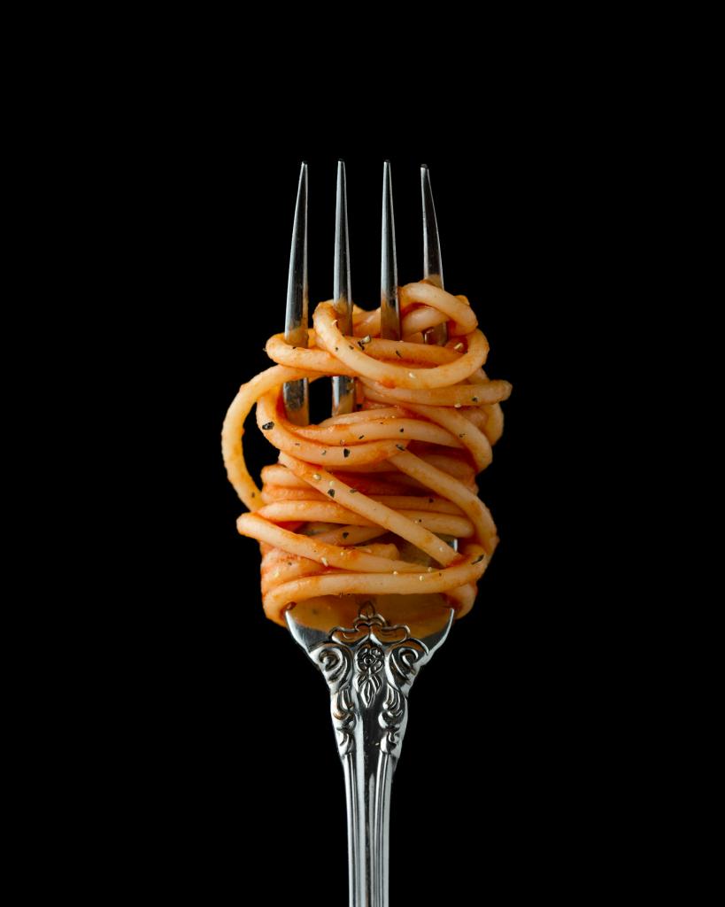 Pasta and sauce are wrapped around a fork.